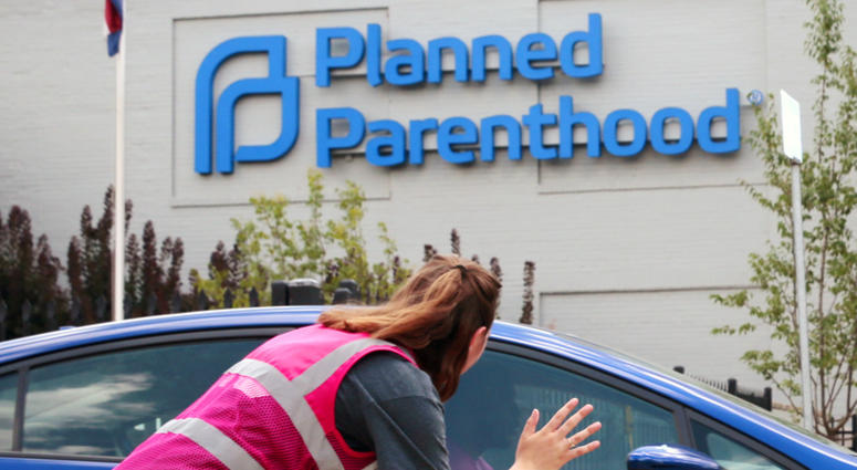 In this June 28, 2019 file photo, Ashlyn Myers of the Coalition for Life St. Louis, waves to a Planned Parenthood staff member in St. Louis, Mo. In this June 28, 2019 file photo, Ashlyn Myers of the Coalition for Life St. Louis, waves to a Planned Parenthood staff member in St. Louis, Mo.