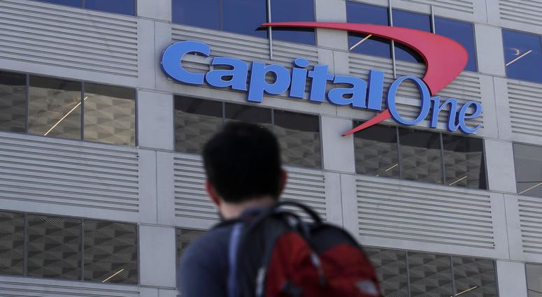 In this July 16, 2019, photo, a man walks across the street from a Capital One location in San Francisco. In this July 16, 2019, photo, a man walks across the street from a Capital One location in San Francisco.