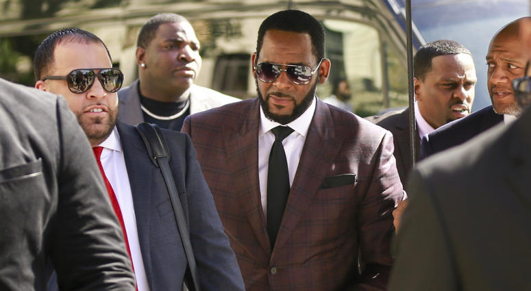 In this June 26, 2019, file photo, R&B singer R. Kelly, center, arrives at the Leighton Criminal Court building for an arraignment on sex-related felonies in Chicago. R. Kelly