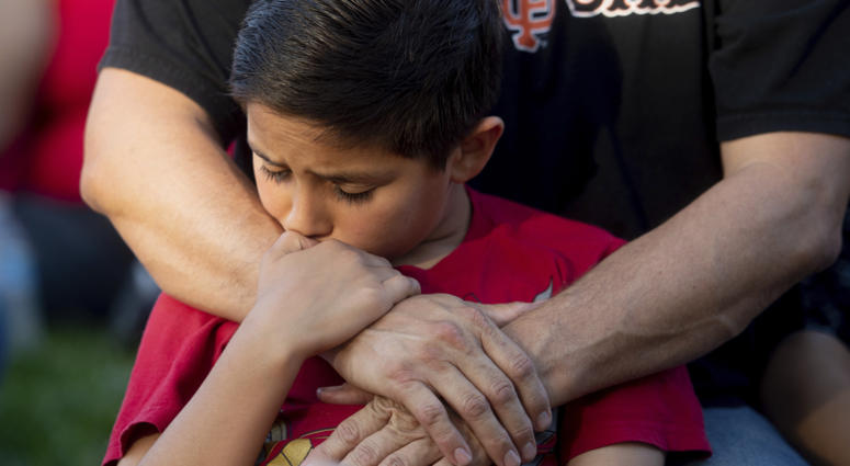 Robbie Ramirez, 10, holds onto his father, Robert Ramirez, during a vigil for victims of a Sunday evening shooting that left three people dead at the Gilroy Garlic Festival, Monday, July 29, 2019, in Gilroy, Calif. Robbie Ramirez, 10, holds onto his father, Robert Ramirez, during a vigil for victims of a Sunday evening shooting that left three people dead at the Gilroy Garlic Festival, Monday, July 29, 2019, in Gilroy, Calif.