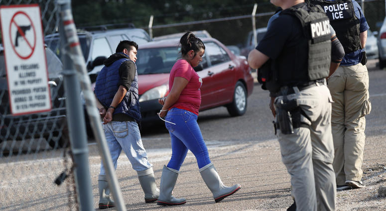 Two people are taken into custody at a Koch Foods Inc. plant in Morton, Miss., on Wednesday, Aug. 7, 2019. Immigration Food Plant Raids