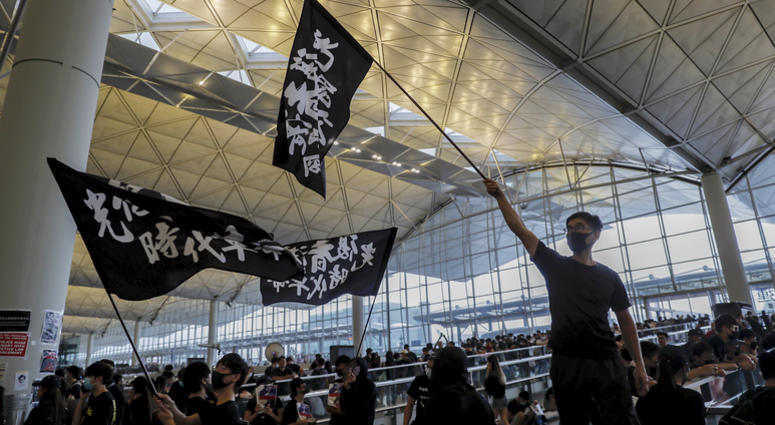 Protesters wave flags at the Hong Kong International Airport, Monday, Aug. 12, 2019. One of the world's busiest airports canceled all flights after thousands of Hong Kong pro-democracy protesters crowded into the main terminal Monday afternoon. Protesters wave flags at the Hong Kong International Airport, Monday, Aug. 12, 2019. One of the world's busiest airports canceled all flights after thousands of Hong Kong pro-democracy protesters crowded into the main terminal Monday afternoon.