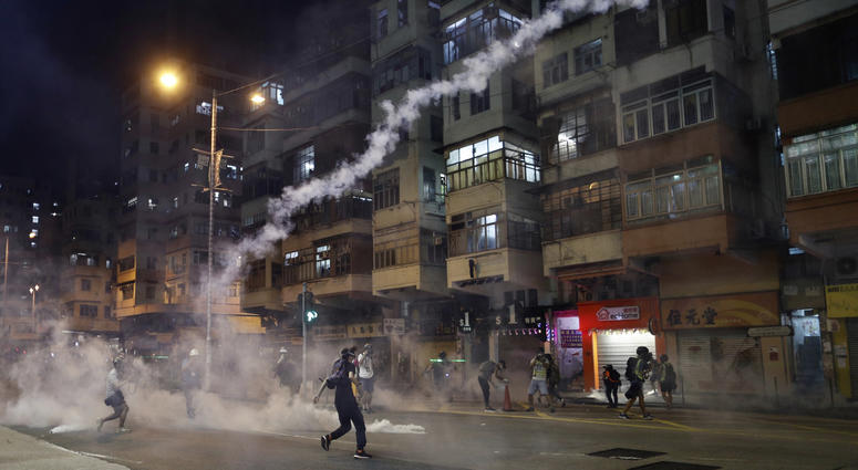 Protesters react to tear gas from Shum Shui Po police station in Hong Kong on Wednesday, Aug. 14, 2019. Protesters react to tear gas from Shum Shui Po police station in Hong Kong on Wednesday, Aug. 14, 2019.
