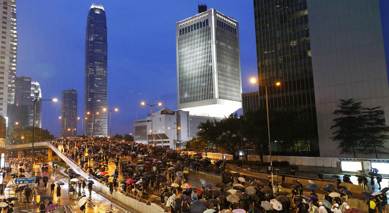 Protesters march in the rain in Hong Kong Sunday, Aug. 18, 2019. Heavy rain fell on tens of thousands of umbrella-toting protesters Sunday as they marched from a packed park and filled a major road in Hong Kong.