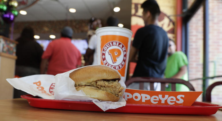 A chicken sandwich sits on a table at a Popeyes as guests wait in line, Thursday, Aug. 22, 2019, in Kyle, Texas. Popeyes chicken sandwich