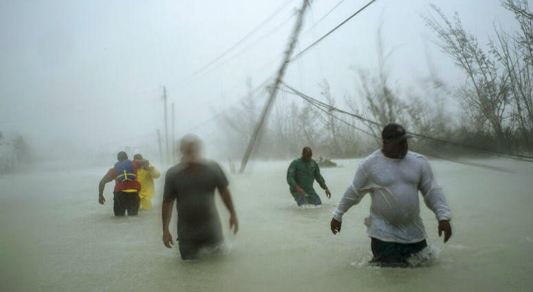 Volunteers walk under the wind and rain from Hurricane Dorian through a flooded road as they work to rescue families near the Causarina bridge in Freeport, Grand Bahama, Bahamas, Tuesday, Sept. 3, 2019. Volunteers walk under the wind and rain from Hurricane Dorian through a flooded road.