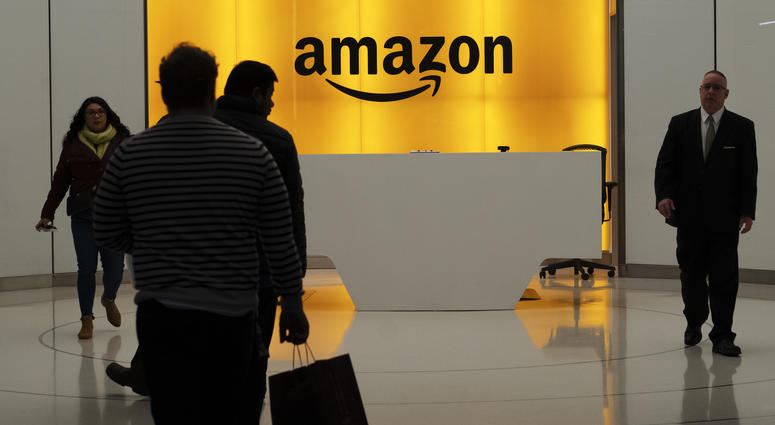 In this Feb. 14, 2019, file photo people walk into the lobby for Amazon offices in New York. In this Feb. 14, 2019, file photo people walk into the lobby for Amazon offices in New York.