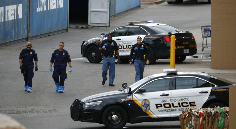 FILE - In this Aug. 6, 2019, file photo, police officers walk behind a Walmart at the scene of a mass shooting at a shopping complex in El Paso, Texas. Police officers walk behind a Walmart at the scene of a mass shooting at a shopping complex in El Paso, Texas.