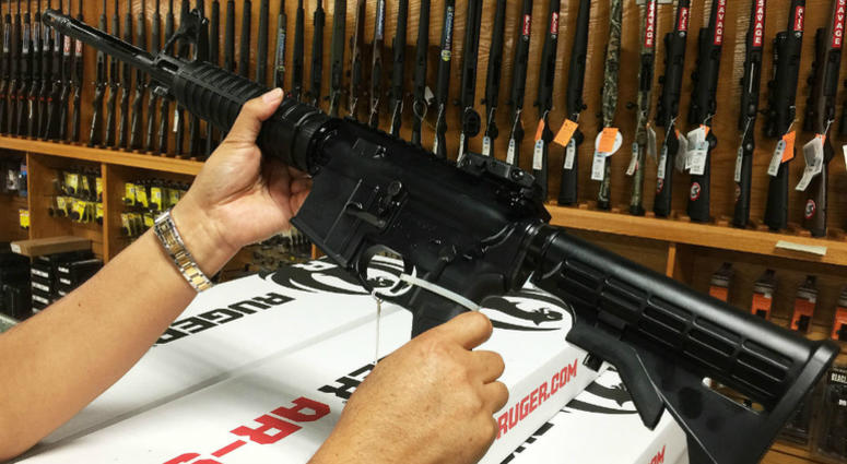 Photo taken with mobile phone on June 13, 2016 shows a customer looking at an AR-15 semi-automatic rifle at a shop in Orlando. a customer looking at an AR-15 semi-automatic rifle
