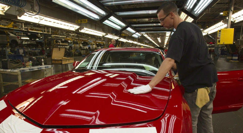 In this June 10, 2011, file photo, a worker checks the paint on a Camaro at the GM factory in Oshawa, Ontario. In this June 10, 2011, file photo, a worker checks the paint on a Camaro at the GM factory in Oshawa, Ontario.