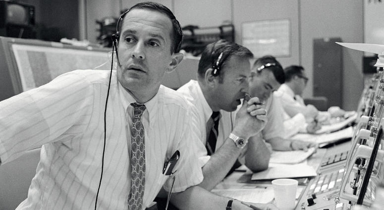 CAPCOM Charles Duke, with backup crewmen Jim Lovell and Fred Haise listening in during Apollo 11's descent CAPCOM Charles Duke, with backup crewmen Jim Lovell and Fred Haise listening in during Apollo 11's descent