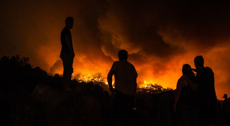 People stand next to the fire before being evacuated at the village of Monchique, in southern Portugal's Algarve region, Sunday, Aug. 5 2018. People stand next to the fire before being evacuated at the village of Monchique, in southern Portugal's Algarve region, Sunday, Aug. 5 2018.