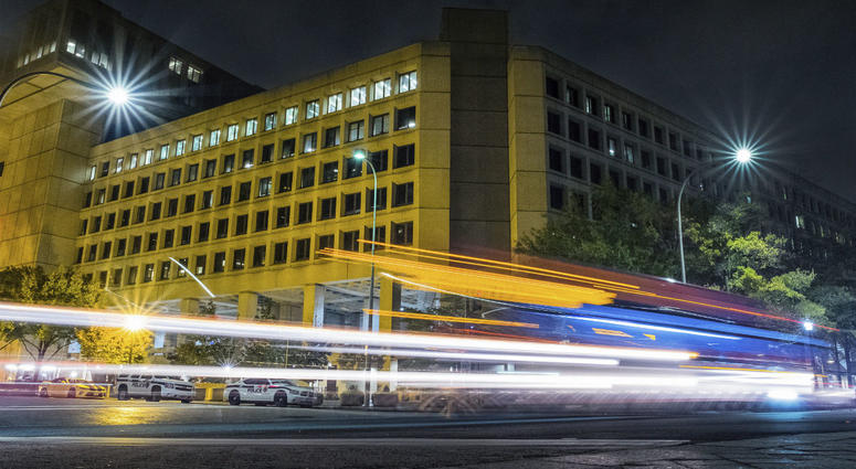 In this Nov. 1, 2017, file photo, traffic along Pennsylvania Avenue in Washington streaks past the Federal Bureau of Investigation headquarters building. In this Nov. 1, 2017, file photo, traffic along Pennsylvania Avenue in Washington streaks past the Federal Bureau of Investigation headquarters building.