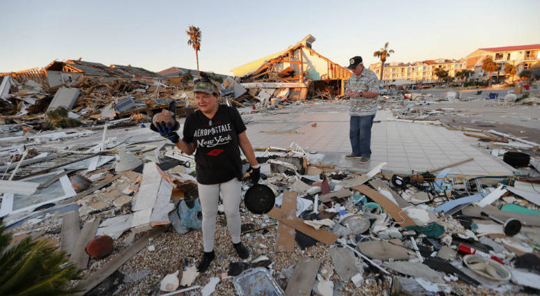 Lavonia Fortner helps her father-in-law, John E. Fortner, search for memorabilia his wife collected, in the aftermath of Hurricane Michael in Mexico Beach, Fla., Saturday, Oct. 13, 2018.