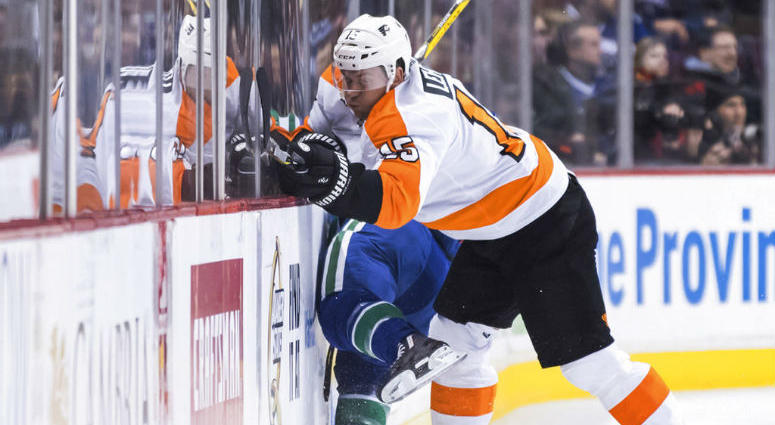 Philadelphia Flyers' Jori Lehtera, front right, of Finland, misses the check on Vancouver Canucks' Alex Biega during the first period of an NHL hockey game in Vancouver, British Columbia, on Saturday, Dec. 15, 2018.