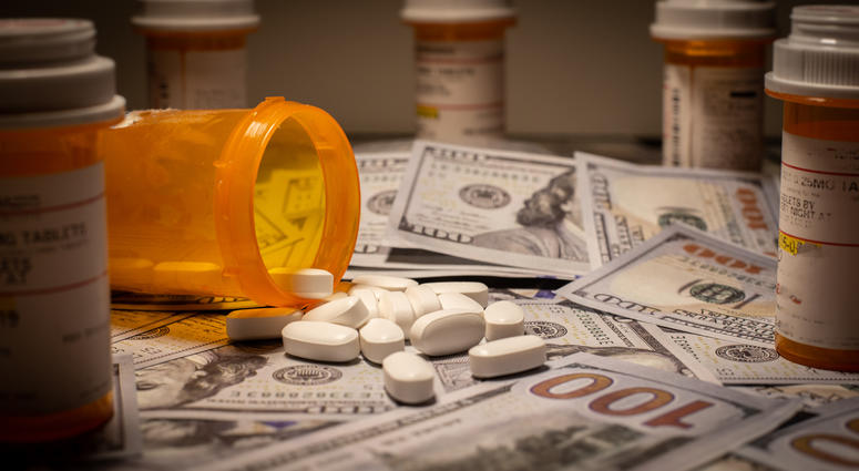 Prescription medication is strewn out upon US currency. Prescription medication