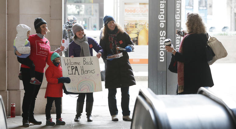 Moms Clean Air Force activists (from left) Liz Brandt, her daughters Natalia, 3, and Valencia Bednar, 5; Martha Roberts and Molly Rauch pose for a while welcoming EPA employees back to work outside a metro station, Jan. 28, 2019 in Washington. Moms Clean Air Force