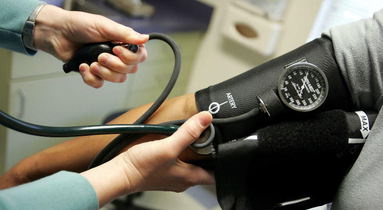 Dr. Elizabeth Maziarka reads a blood pressure gauge during an examination of patient June Mendez at the Codman Square Health Center April 11, 2006 in Dorchester, Massachusetts. blood pressure