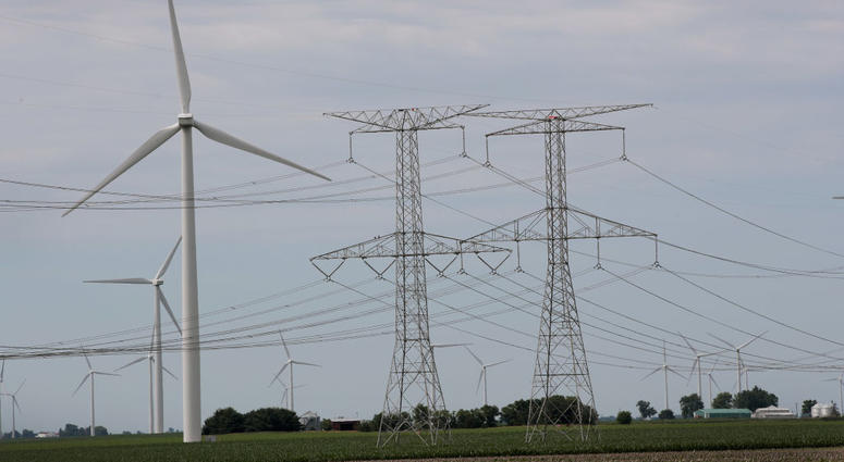 Power lines and power generating windmills rise above the rural landscape on June 14, 2018 near Dwight, Illinois. Power lines and power generating windmills