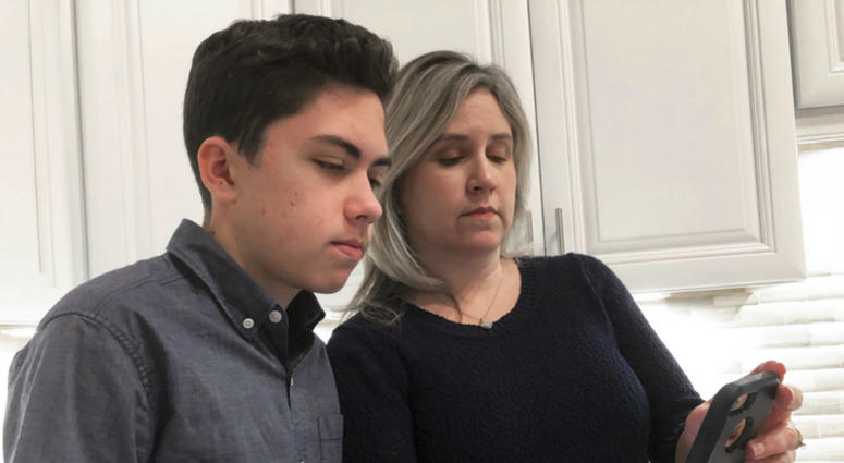 Grant Thompson and his mother, Michele, look at an iPhone in the family's kitchen in Tucson, Ariz., on Thursday, Jan. 31, 2019. Grant Thompson and his mother, Michele, look at an iPhone in the family's kitchen in Tucson, Ariz., on Thursday, Jan. 31, 2019.
