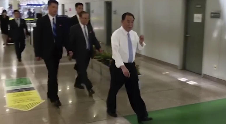 In this image made from video, Kim Yong Chol, right, a former military intelligence chief who is now Kim Jong Un's top official on inter-Korean relations, walks through Beijing airport after his arrival Tuesday, May 29, 2018. Kim Yong Chol