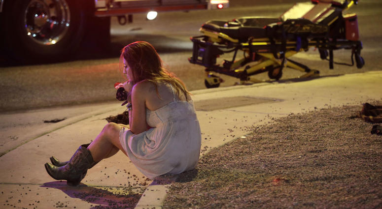 In this Oct. 2, 2017 file photo, a woman sits on a curb at the scene of a shooting outside a music festival on the Las Vegas Strip. It took 11 minutes for the gunman in the deadliest mass shooting in modern U.S. history to kill 58 people. In this Oct. 2, 2017 file photo, a woman sits on a curb at the scene of a shooting outside a music festival on the Las Vegas Strip. It took 11 minutes for the gunman in the deadliest mass shooting in modern U.S. history to kill 58 people.