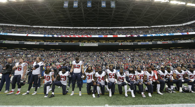 In this Oct. 29, 2017, file photo, Houston Texans players kneel and stand during the singing of the national anthem before an NFL football game against the Seattle Seahawks, in Seattle. In this Oct. 29, 2017, file photo, Houston Texans players kneel and stand during the singing of the national anthem before an NFL football game against the Seattle Seahawks, in Seattle.