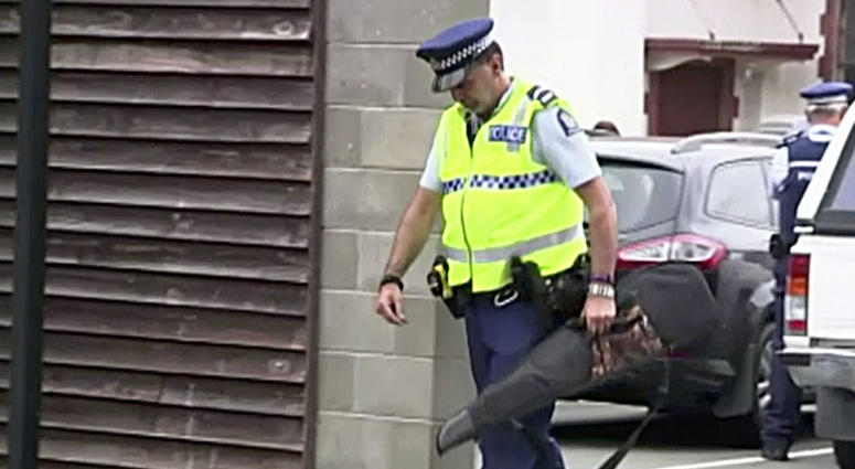 In this image made from video taken March 19, 2019, a police officer carries a gun voluntarily surrendered by a member of the public into the Masterton police station in Masterton, New Zealand. In this image made from video taken March 19, 2019, a police officer carries a gun voluntarily surrendered by a member of the public into the Masterton police station in Masterton, New Zealand.