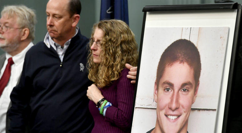 In this May 5, 2017, file photo, Jim and Evelyn Piazza, center, stand by as Centre County, Pa., prosecutors discuss an investigation into the death of their son Timothy Piazza, seen in photo at right, during a news conference. Jim and Evelyn Piazza stand by as Centre County, Pa., prosecutors discuss an investigation into the death of their son Timothy Piazza