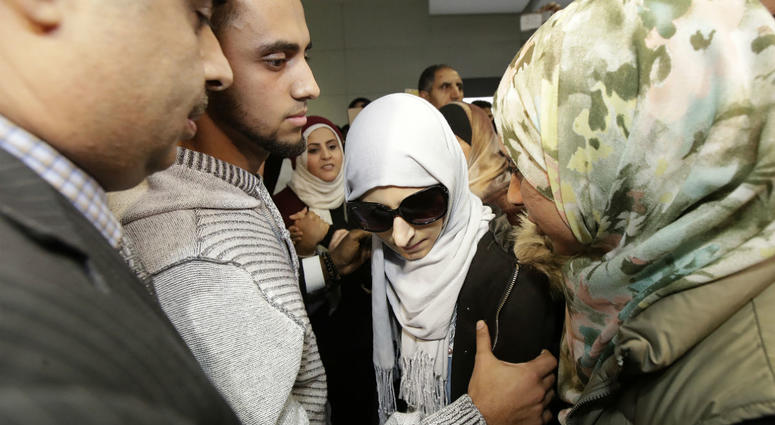Shaima Swileh, center, stands with her husband Ali Hassan, second from left, after Swileh arrived at San Francisco International Airport in San Francisco, Wednesday, Dec. 19, 2018. Shaima Swileh, center, stands with her husband Ali Hassan, second from left, after Swileh arrived at San Francisco International Airport in San Francisco, Wednesday, Dec. 19, 2018.