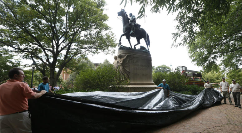 In this Aug. 23, 2017, file photo, city workers prepare to drape a tarp over the statue of Confederate General Stonewall Jackson in Justice park in Charlottesville, Va. In this Aug. 23, 2017, file photo, city workers prepare to drape a tarp over the statue of Confederate General Stonewall Jackson in Justice park in Charlottesville, Va.