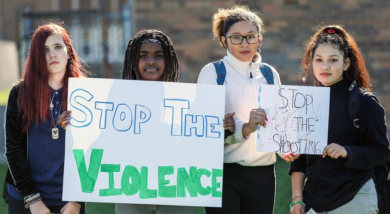 From left: On April 20, 2018 in Indianapolis, Elizabeth Starker, 12; Precious Allen, 13; Viridiana Coria, 14; and Diana Peralta, 13; hold signs after walking out of Longfellow Middle on the 19th anniversary of the Columbine school shooting. student walkouts