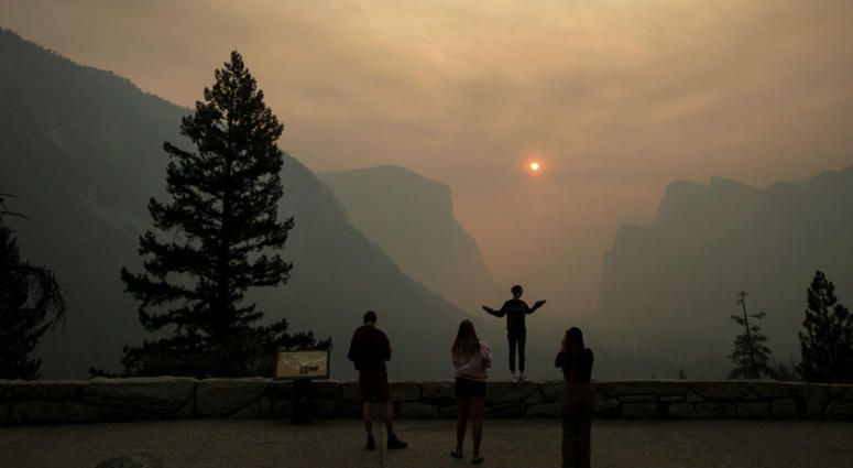 In this July 25, 2018 file photo, Hannah Whyatt poses for a friend's photo as smoke from the Ferguson fire fills Yosemite Valley in Yosemite National Park, Calif. In this July 25, 2018 file photo, Hannah Whyatt poses for a friend's photo as smoke from the Ferguson fire fills Yosemite Valley in Yosemite National Park, Calif.