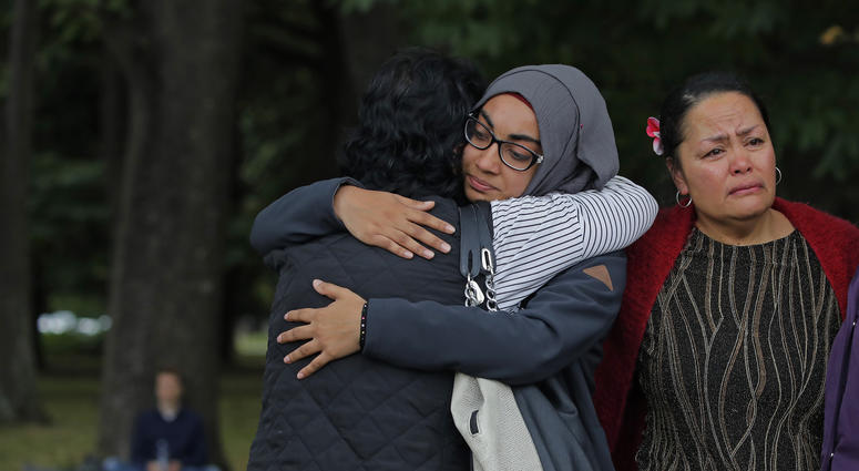 Mourners hug after paying their respects to the victims near the Masjid Al Noor mosque in Christchurch, New Zealand, Monday, March 18, 2019. A steady stream of mourners paid tribute at makeshift memorial to the 50 people slain by a gunman at two mosques i Mourners hug after paying their respects to the victims near the Masjid Al Noor mosque in Christchurch, New Zealand, Monday, March 18, 2019. A steady stream of mourners paid tribute at makeshift memorial to the 50 people slain by a gunman at two mosques i
