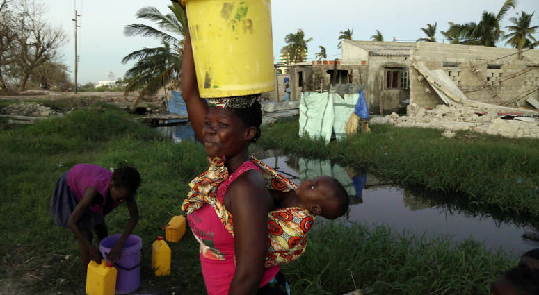 A woman carrying water and a baby on her back after collecting water in Beira, Mozambique, Monday, March 25, March 24, 2019. A woman carrying water and a baby on her back after collecting water in Beira, Mozambique, Monday, March 25, March 24, 2019.
