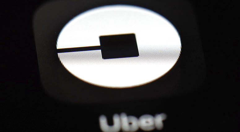 FILE - This March 20, 2018, file photo shows the Uber app on an iPad in Baltimore. Uber is about to embark on a wild ride on Wall Street with the biggest and most hotly debated IPO in years. Uber is about to embark on a wild ride on Wall Street with the biggest and most hotly debated IPO in years. Uber's shares begin trading on the New York Stock Exchange, Friday, May 10, 2019.