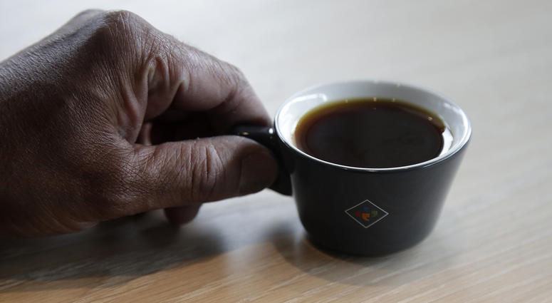 Klatch Coffee owner Bo Thiara holds a cup of Elida Natural Geisha coffee at his shop in San Francisco, Wednesday, May 15, 2019. The California cafe is brewing up what it calls the world's most expensive coffee - at $75 a cup.