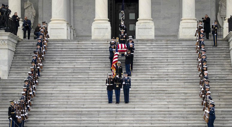 A U.S. military honor guard carries the flag-draped casket of the late former President George H.W. Bush down the steps of the U.S. Capitol, December 5, 2018 in Washington, DC. A U.S. military honor guard carries the flag-draped casket of the late former President George H.W. Bush down the steps of the U.S. Capitol, December 5, 2018 in Washington, DC.