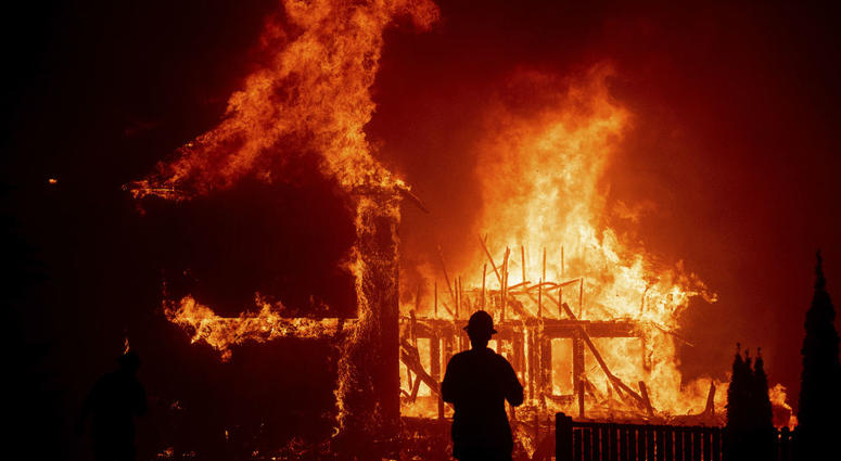 In this Thursday, Nov. 8, 2018 file photo, a home burns as the Camp Fire rages through Paradise, Calif. Authorities say the fire is 95 percent contained Thursday, Nov. 22. In this Thursday, Nov. 8, 2018 file photo, a home burns as the Camp Fire rages through Paradise, Calif. Authorities say the fire is 95 percent contained Thursday, Nov. 22.