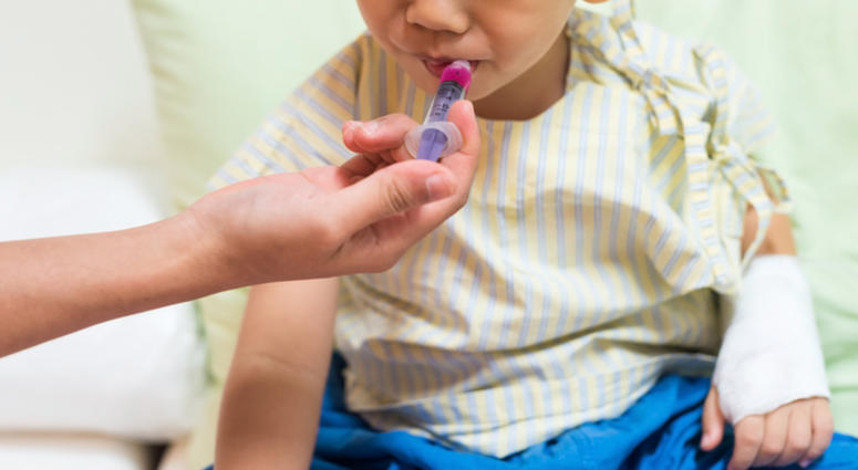 A child is fed liquid medicine for respiratory syncytial virus. A child is fed liquid medicine for respiratory syncytial virus.