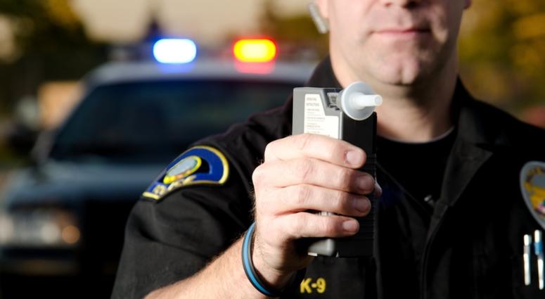 Police officer holding a breathalyzer breathalyzer
