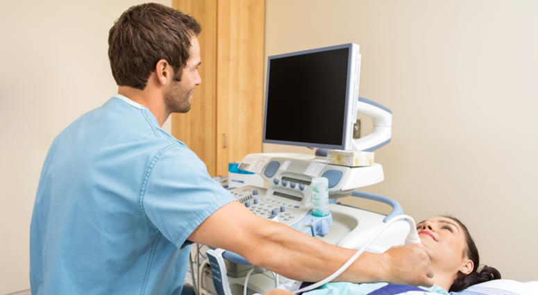Male nurse performing ultrasound on young patient's neck in examination room Male Nurse