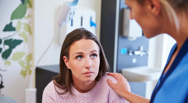 Female Patient Being Reassured By Nurse In Hospital Room Nurse with female patient