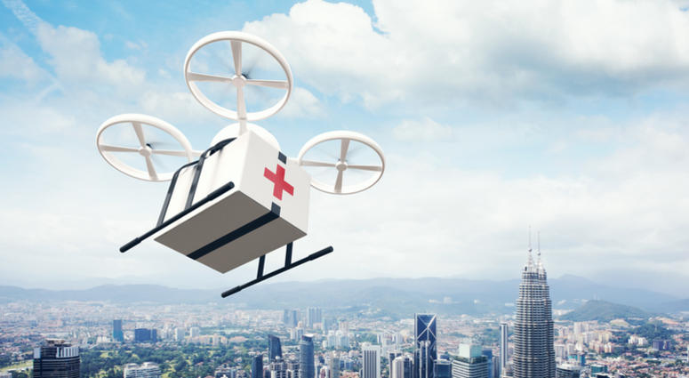 Photo White Generic Design Remote Control Air Drone Flying Sky Medical Box Under Urban Surface. Medical Drone