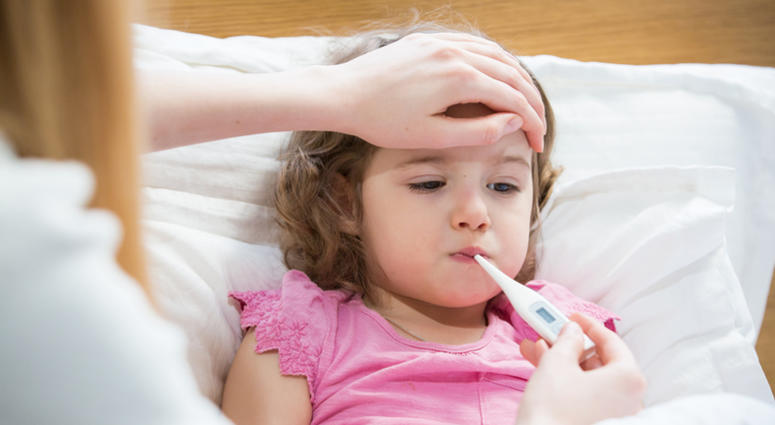 Sick child with high fever laying in bed and mother holding thermometer. Sick Child