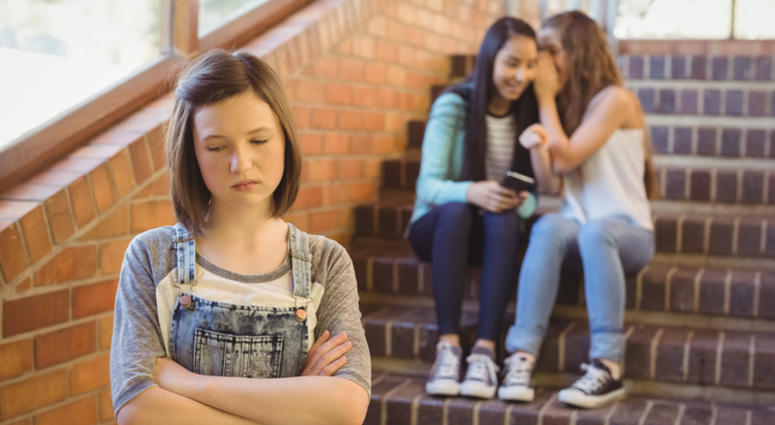 School friends bullying a sad girl in school corridor at school Bullying