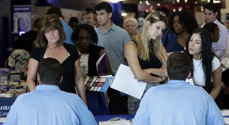In this June 21, 2018, file photo, job applicants talks with representatives from Aldi at a job fair hosted by Job News South Florida, in Sunrise, Fla. On Friday, Oct. 5, the U.S. government issues the September jobs report. In this June 21, 2018, file photo, job applicants talks with representatives from Aldi at a job fair hosted by Job News South Florida, in Sunrise, Fla. On Friday, Oct. 5, the U.S. government issues the September jobs report.