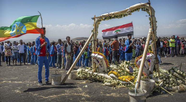Students from Hama elementary school, who walked an hour and a half from their school in the surrounding area to pay their respects, stand next to floral tributes at the scene where the Ethiopian Airlines Boeing 737 Max 8 crashed Students from Hama elementary school, who walked an hour and a half from their school in the surrounding area to pay their respects, stand next to floral tributes at the scene where the Ethiopian Airlines Boeing 737 Max 8 crashed