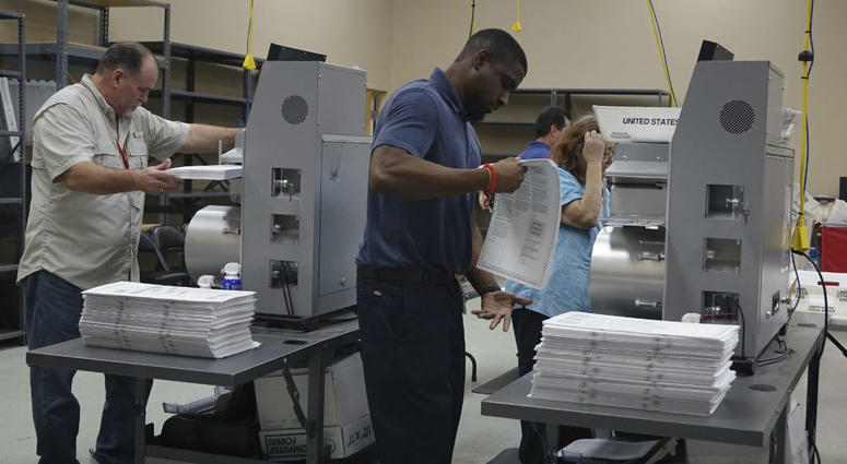 Election workers place ballots into electronic counting machines, Sunday, Nov. 11, 2018, at the Broward Supervisor of Elections office in Lauderhill, Fla. Election workers place ballots into electronic counting machines, Sunday, Nov. 11, 2018, at the Broward Supervisor of Elections office in Lauderhill, Fla.