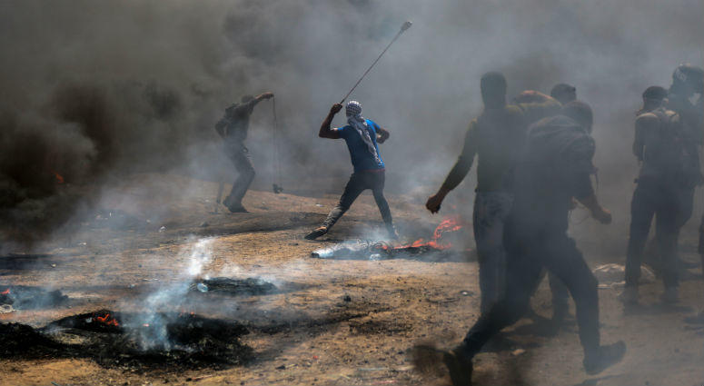 Palestinian protesters use slingshots to hurl stones at Israeli troops during clashes in Gaza, on May 14, 2018. Palestinian protesters use slingshots to hurl stones at Israeli troops